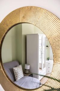 a mirror in a bedroom with a bed at Cocon aux portes de Paris in Clichy