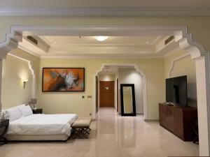 a bedroom with a bed and a flat screen tv at Al Hamra golf & sea resort lagoon view suite in Ras al Khaimah