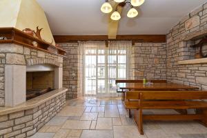 a living room with a stone fireplace and a wooden bench at House Golubovo 2326 in Mednjan