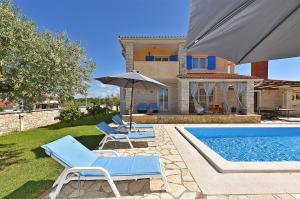 a house with a swimming pool and two chairs and an umbrella at House Golubovo 2326 in Mednjan