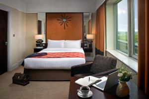 a hotel room with a bed and a desk at Carlton Hotel Blanchardstown in Blanchardstown