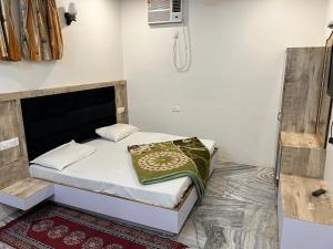 Un dormitorio pequeño con una cama en una habitación. en Hotel Chintpurni, en Katra