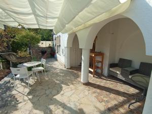 eine Terrasse mit einem Tisch, Stühlen und einem Sonnenschirm in der Unterkunft Casa Morisca in Tossa de Mar