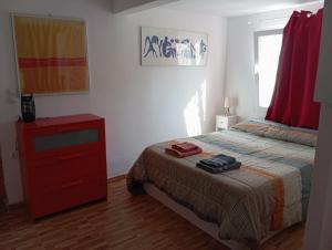 a bedroom with a bed with a red dresser and a red drawer at Casa Morisca in Tossa de Mar