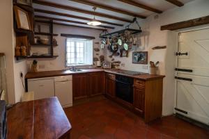 a kitchen with wooden cabinets and a black stove top oven at Mountain Cottage in Llanaelhaiarn