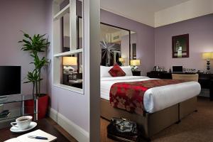 a hotel room with a bed and a mirror at Carlton Hotel Blanchardstown in Blanchardstown