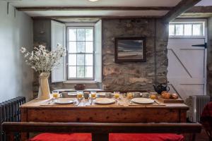 a table with plates and candles on it in a room at Mountain Cottage in Llanaelhaiarn +34 photos