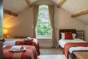 a bedroom with two beds and a window at Mountain Cottage in Llanaelhaiarn