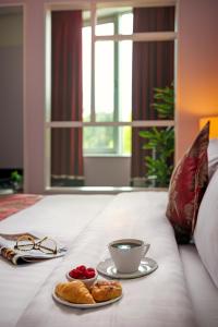 een dienblad met een kopje koffie en gebak op een bed bij Carlton Hotel Blanchardstown in Blanchardstown