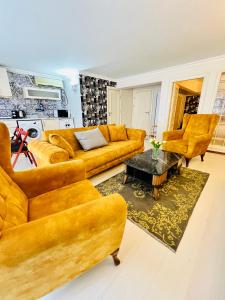 uma sala de estar com sofás amarelos e uma mesa em VG taksim em Istambul