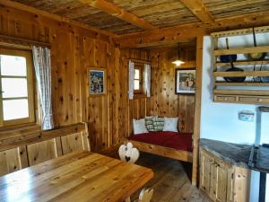 Blockhütte mit einem Bett und einem Tisch in der Unterkunft Bergquellenhütte in Assling