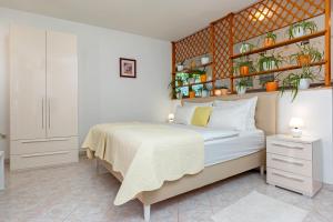 Studio Apartment Oliva في بولا: غرفة نوم مع سرير والنباتات على الحائط