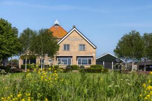 ein Haus mit einem Blumenfeld davor in der Unterkunft Jantje Slot Hoeve in Oosterzee