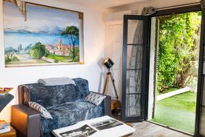- un salon avec un canapé bleu et une fenêtre dans l'établissement la Romana Luxe et sérénité au cœur de Saint-Tropez Suites spacieuses avec jardin enchanteur, à Saint-Tropez