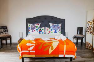 sypialnia z łóżkiem z pomarańczowym kocem w obiekcie la Romana Luxe et sérénité au cœur de Saint-Tropez Suites spacieuses avec jardin enchanteur w Saint-Tropez