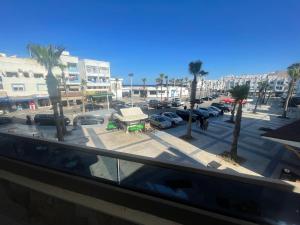 vistas a un aparcamiento con palmeras y coches en ANNI Guesthouse Hostel, en Martil