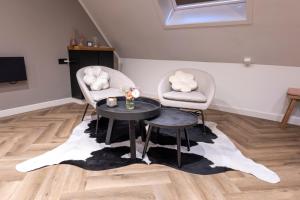 ein Wohnzimmer mit 2 Stühlen und einem Tisch in der Unterkunft Jantje Slot Hoeve in Oosterzee