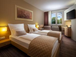 um quarto de hotel com duas camas e uma televisão em Ahotel Ljubljana em Ljubljana