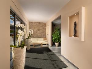 a living room with a couch and a vase with flowers at Ahotel Ljubljana in Ljubljana