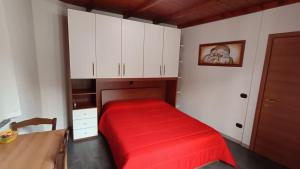 een slaapkamer met een rood bed en witte kasten bij Casa Mango in Stresa