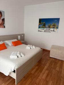 1 dormitorio con 1 cama con sábanas blancas y almohadas de color naranja en BnB Nuova Vita, en Paola