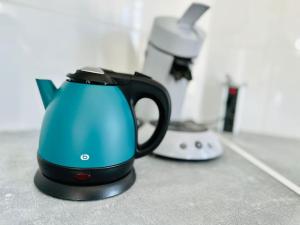 a blue tea kettle sitting on a counter with a appliance at Chez Pierrot à 180m de la mer à Cayeux sur mer in Cayeux-sur-Mer