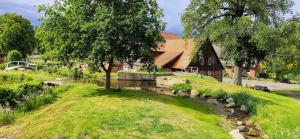 ein Haus mit einem Fluss vor einem Gebäude in der Unterkunft Bruchmühlen in Bruchhausen-Vilsen