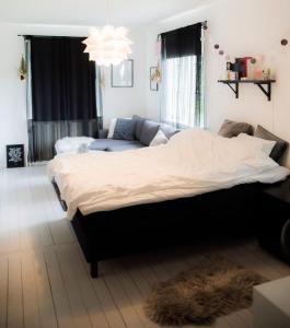 a bedroom with a large bed and a couch at Västervik rum & Stugor in Västervik