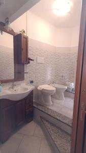 een badkamer met een wastafel, een toilet en een bad bij Casa Mango in Stresa