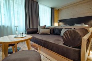 een woonkamer met een bank en een bed bij Hotel Partizán in Tale