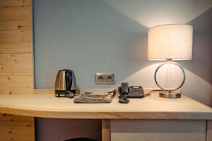 a desk with a lamp and a phone on it at Hotel Partizán in Tale