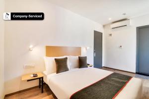Super Townhouse Ulsoor Near Halasuru Metro Station في بانغالور: غرفة نوم مع سرير أبيض كبير في غرفة