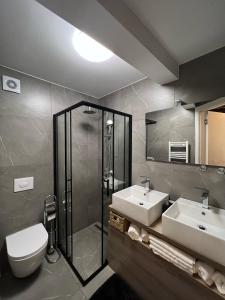 a bathroom with two sinks and a shower and a toilet at Casa Salvia in Koper