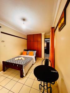 a bedroom with a bed and a chair in it at Studio room entebbe in Entebbe