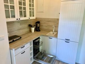 a kitchen with white cabinets and a sink at Ferienwohnung "Perle im Grünen" in Federow