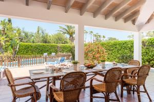 een eetkamer met een tafel en stoelen op een patio bij Villa Angel in Son Xoriguer