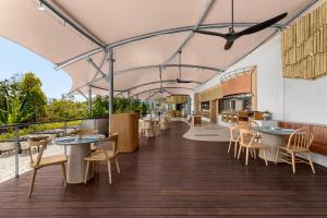 a restaurant with tables and chairs on a balcony at Perhentian Marriott Resort & Spa in Perhentian Islands +37 photos
