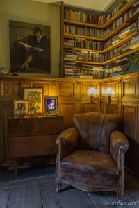 a leather chair in a room with bookshelves at B&B Chez tante Alice in Durbuy
