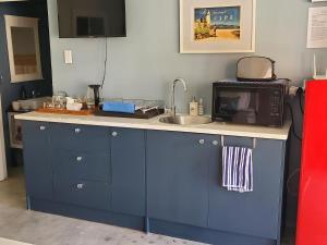 eine Küchentheke mit Mikrowelle und Spüle in der Unterkunft Simply Rus in Oudtshoorn