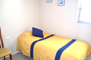 une chambre avec un lit avec un oreiller bleu dessus dans l'établissement Vive San Alfonso del Mar, à Algarrobo 20 autres photos