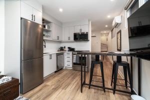 a kitchen with white cabinets and a stainless steel refrigerator at Capital Apartments in Ottawa +7 photos