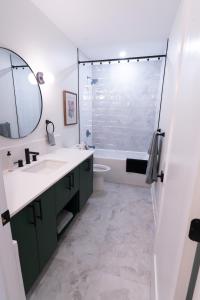 a bathroom with a sink and a tub and a mirror at Capital Apartments in Ottawa