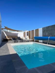 a swimming pool with an inflatable pool slide at villa del mar puerto del carmen in Puerto del Carmen