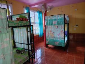 RuengsriSiri Guesthouse في سوخوثاي: سريرين بطابقين في غرفة مع ستائر