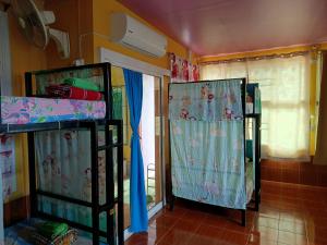 2 literas en una habitación con ventana en RuengsriSiri Guesthouse en Sukhothai