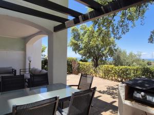 un patio con tavolo, sedie e griglia di Apartamento en Los Monteros a Marbella