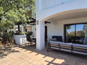 un patio con panchina, tavolo e sedie di Apartamento en Los Monteros a Marbella
