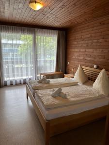 sypialnia z 2 łóżkami i dużym oknem w obiekcie Gasthof Stern w mieście Vandans