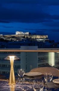 a table with glasses and a lamp on top of a building at Heritage Hill Hotel in Athens