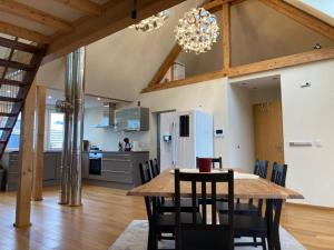 a kitchen and dining room with a wooden table and chairs at Saarburg Wine Apartments in Saarburg